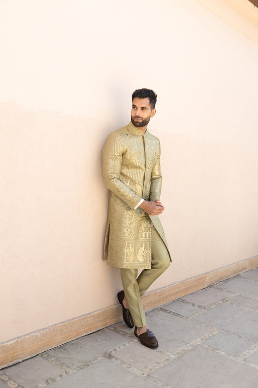 The olive green sherwani set, crafted from luxurious silk fabric